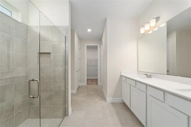a bathroom with a double vanity sink mirror and shower
