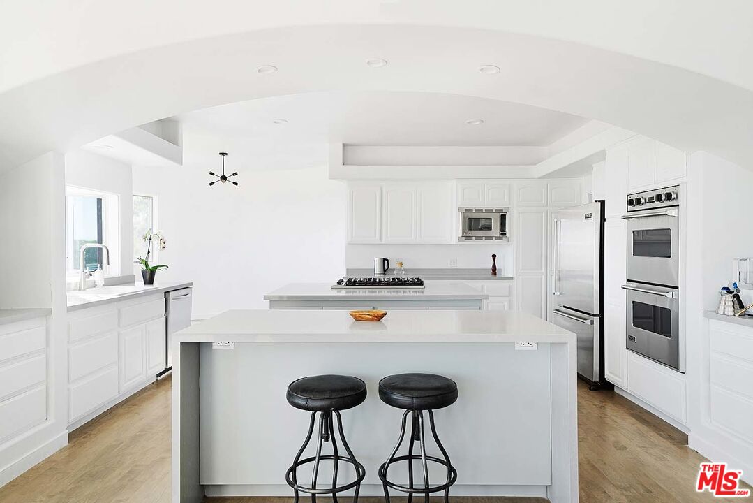 20370 Skyhawk Lane Topanga, CA 90265 - Photo 16 of 43 a kitchen with stainless steel appliances a sink and a refrigerator