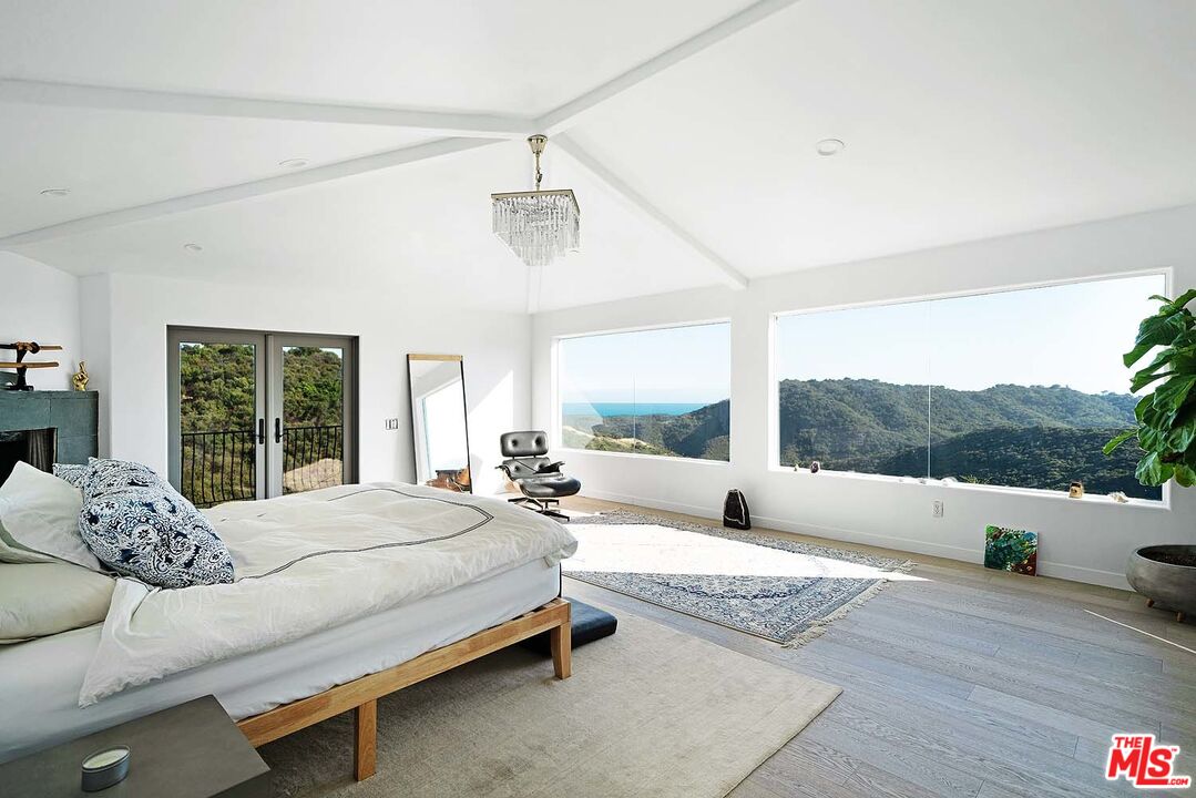 20370 Skyhawk Lane Topanga, CA 90265 - Photo 19 of 43 a bedroom with a bed couch and a large window