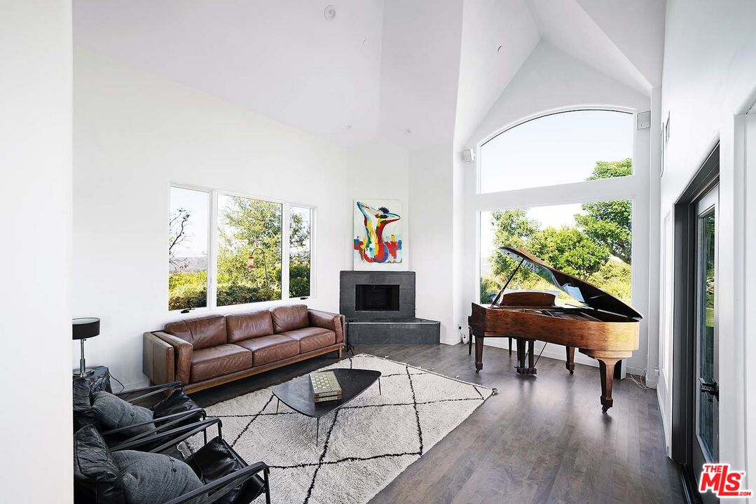 20370 Skyhawk Lane Topanga, CA 90265 - Photo 8 of 43 a living room with furniture a fireplace and a large window
