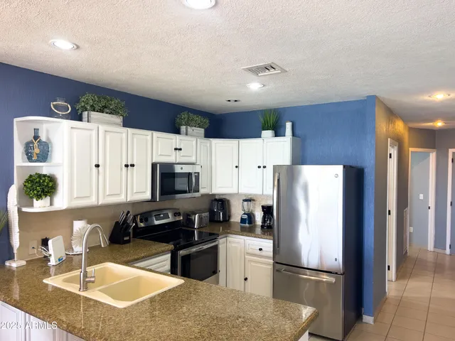 a living room with furniture a floor to ceiling window and a potted plant