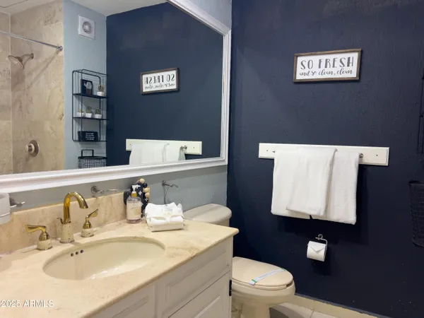 a kitchen with granite countertop a refrigerator a sink a stove a microwave a counter space and cabinets