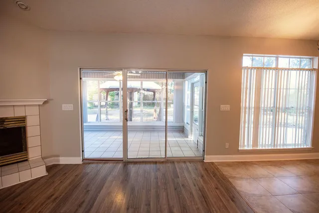 wooden floor fireplace and windows in an empty room