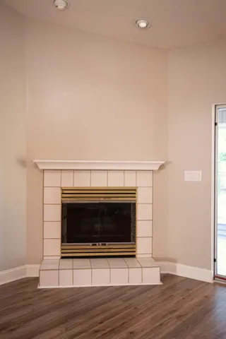a view of a livingroom with wooden floor and a fireplace