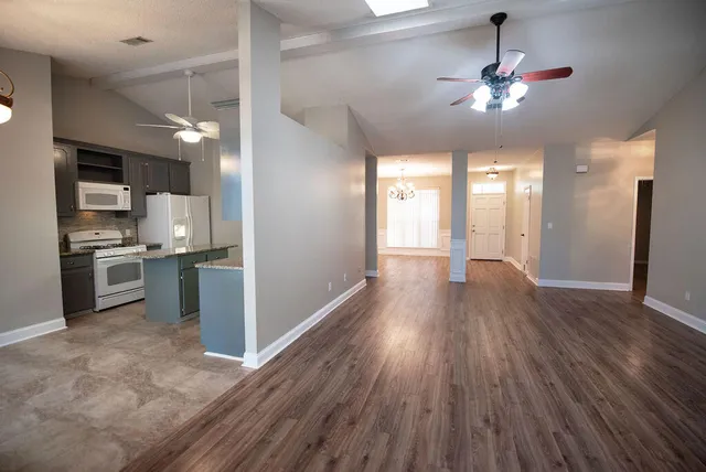 a view of a kitchen center island wooden floor and stainless steel appliances