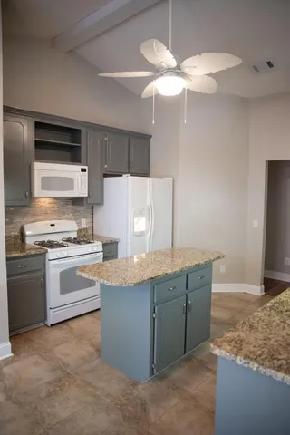 a kitchen with stainless steel appliances granite countertop a sink a stove and a refrigerator