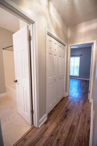 a view of an empty room with wooden floor
