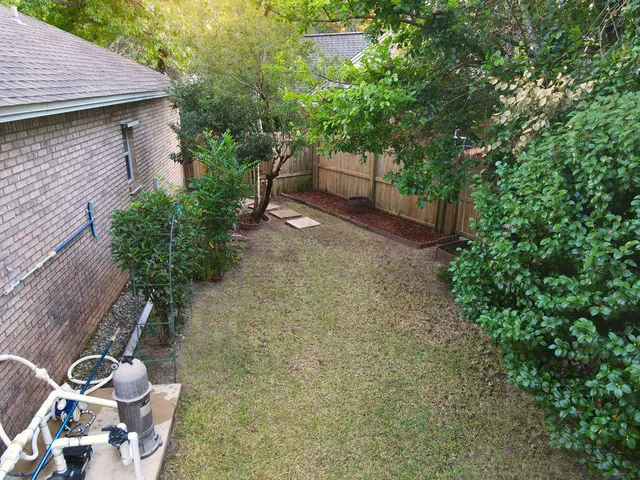 a view of backyard with green space and wooden fence