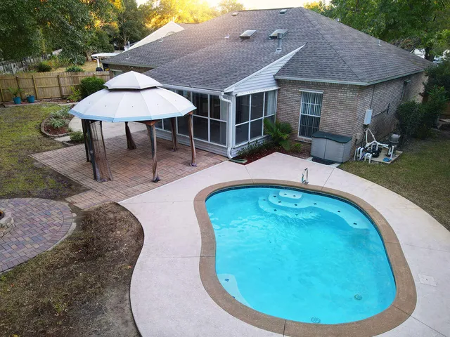 an aerial view of a house with swimming pool garden and patio