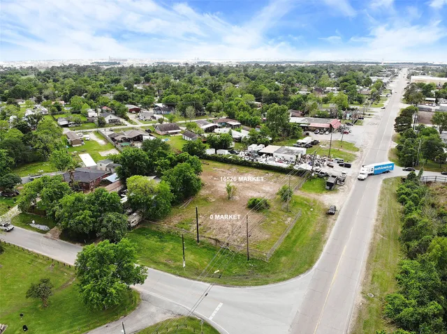 an aerial view of residential houses with outdoor space and trees