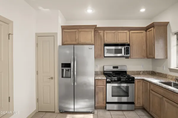 a kitchen with stainless steel appliances granite countertop a refrigerator stove and microwave