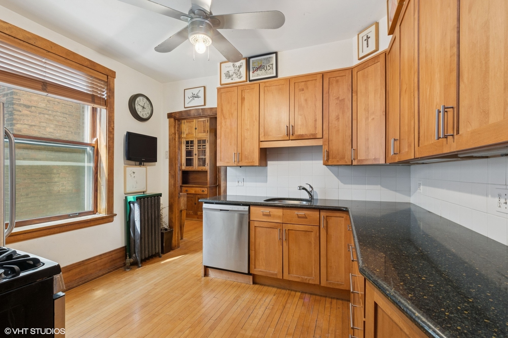 5863 North Kenmore Avenue, Unit 2 Chicago, IL 60660 - Photo 9 of 26 a kitchen with stainless steel appliances granite countertop wooden cabinets a refrigerator and a sink