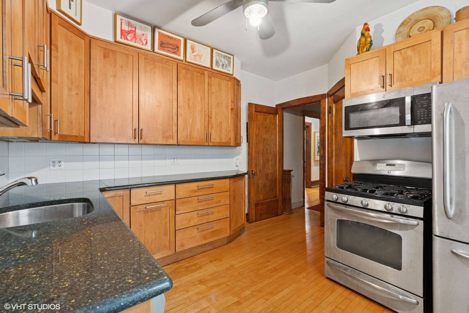 5863 North Kenmore Avenue, Unit 2 Chicago, IL 60660 - Photo 10 of 26 a kitchen with stainless steel appliances granite countertop a stove a sink and a microwave