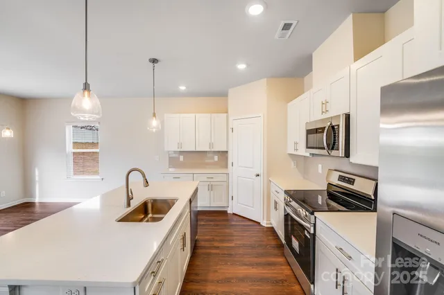 a kitchen with kitchen island a stove a sink and a refrigerator