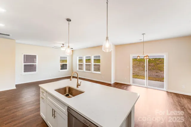a kitchen with a sink a counter top space and wooden floor