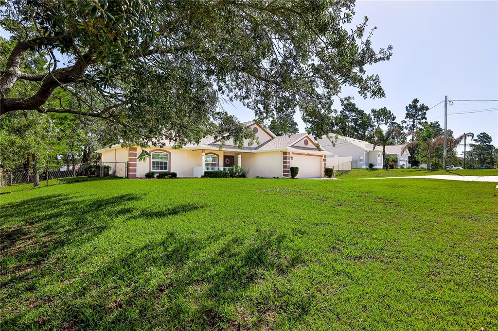 11213 Flock Avenue Weeki Wachee, FL 34613 - Photo 43 of 46 a white house with a big yard and large trees