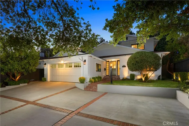 a front view of a house with a yard and trees