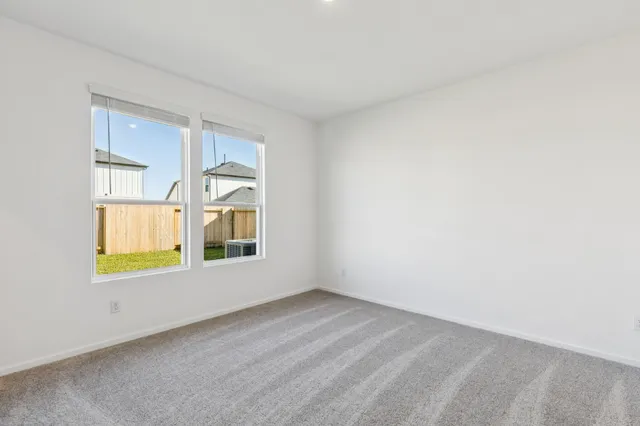 an empty room with a window and wooden floor