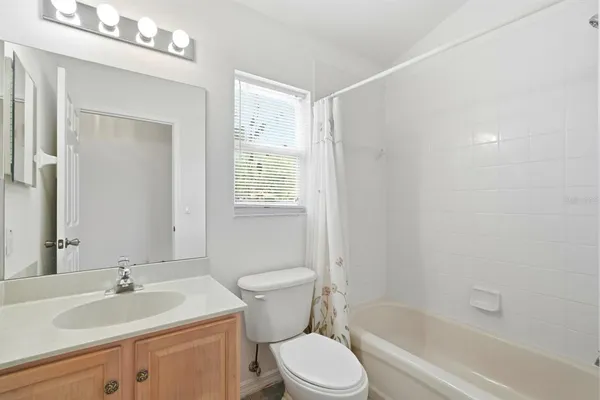 a bathroom with a granite countertop toilet a sink and a bathtub