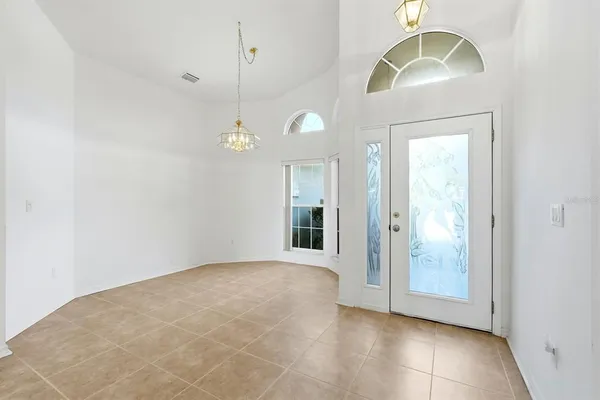 a view of a livingroom with a chandelier fan and windows