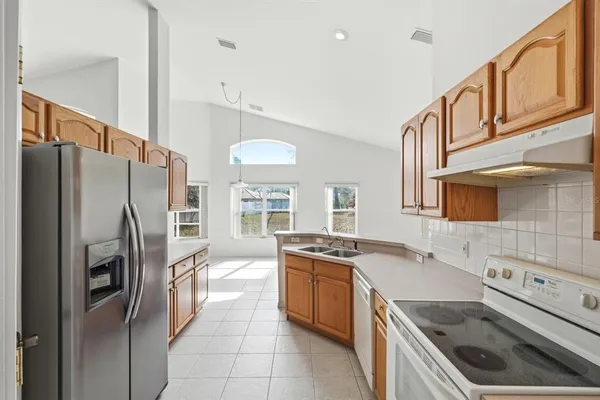 a kitchen that has a sink a refrigerator and a stove