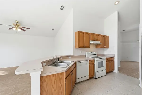 a kitchen with a stove sink and cabinets
