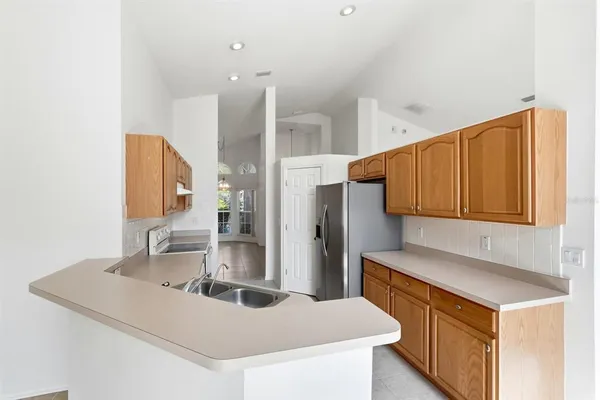 a kitchen with stainless steel appliances granite countertop a sink and a refrigerator