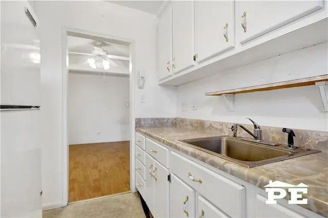 a kitchen with white cabinets and sink