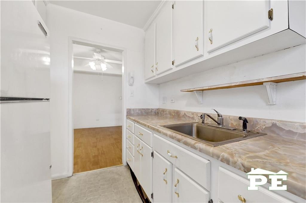 2425 Haring Street, Unit 4G Brooklyn, NY 11235 - Photo 19 of 29 a kitchen with white cabinets and sink