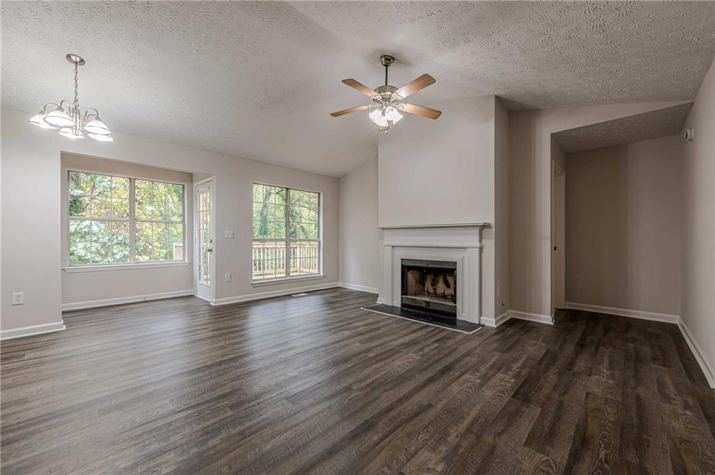 1276 To Lani Farm Road Stone Mountain, GA 30083 - Photo 2 of 16 a view of an empty room with wooden floor fireplace and a window