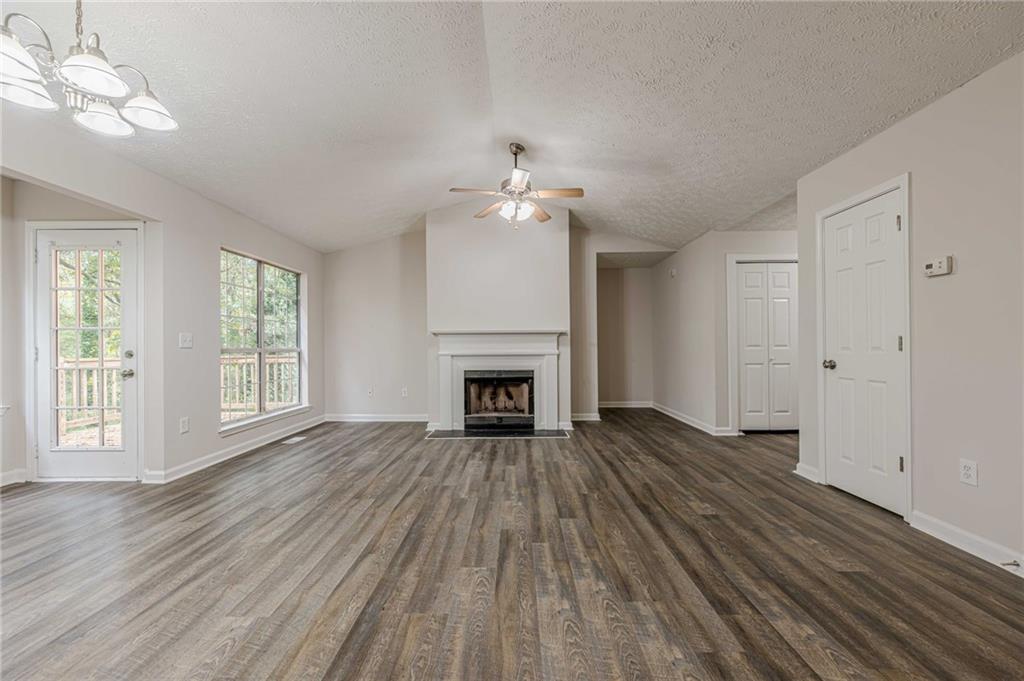 1276 To Lani Farm Road Stone Mountain, GA 30083 - Photo 3 of 16 a view of an empty room with wooden floor fireplace and a window