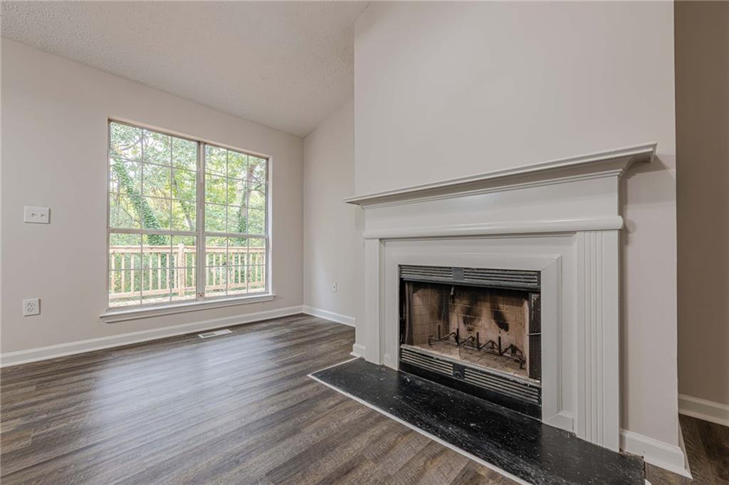 1276 To Lani Farm Road Stone Mountain, GA 30083 - Photo 4 of 16 a living room with a fireplace with wooden floor