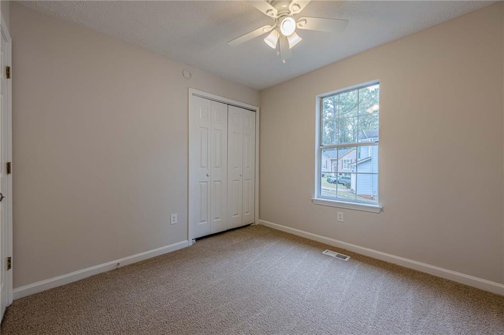 1276 To Lani Farm Road Stone Mountain, GA 30083 - Photo 6 of 16 an empty room with a chandelier fan