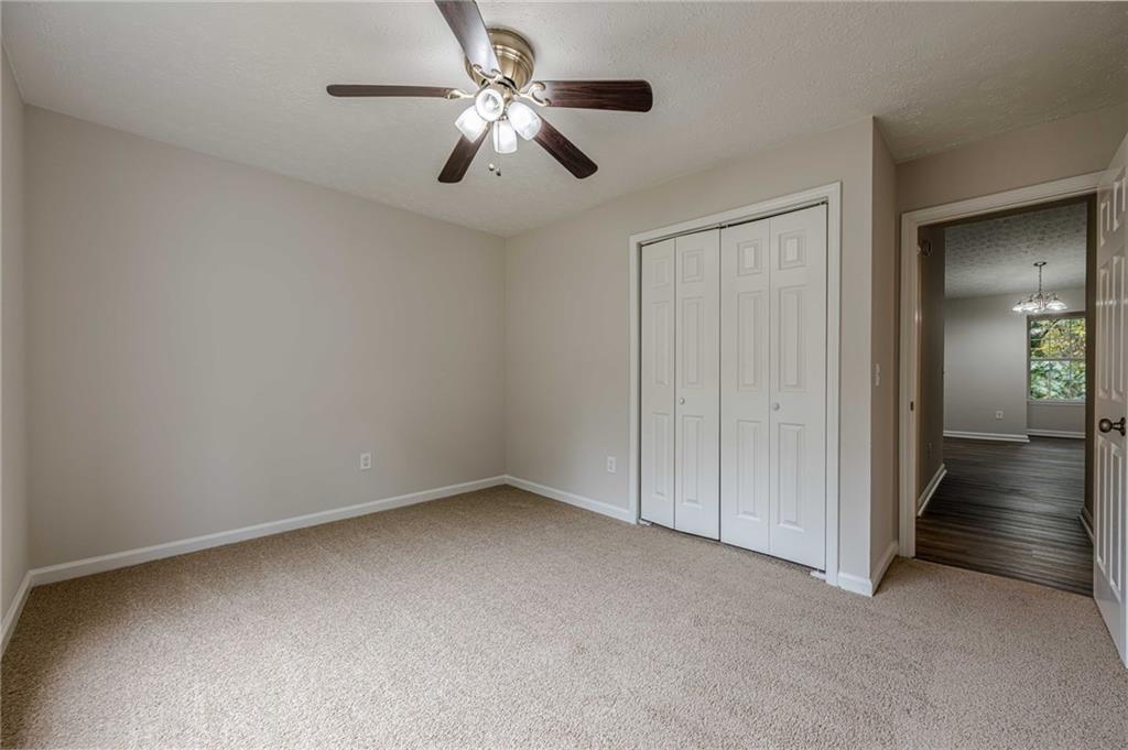 1276 To Lani Farm Road Stone Mountain, GA 30083 - Photo 8 of 16 an empty room with a chandelier fan and windows