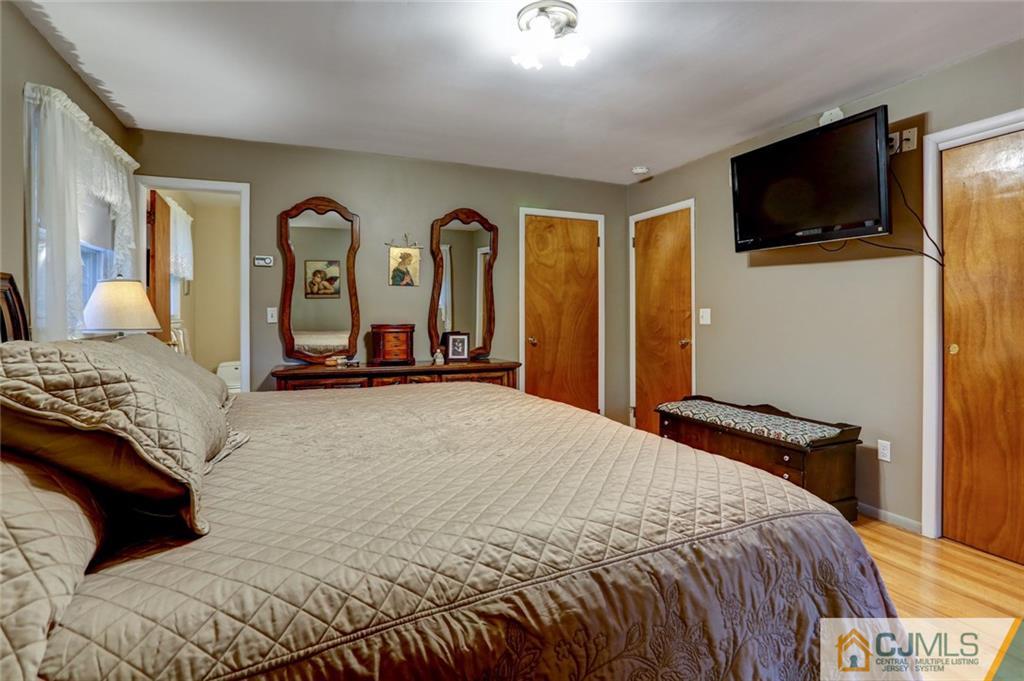 300 Aldrich Road Howell, NJ 07731 - Photo 11 of 19 a bedroom with a bed and a flat tv screen on wall