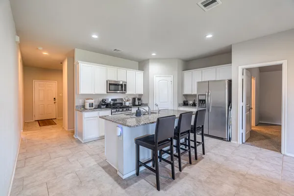 a kitchen with refrigerator and chairs