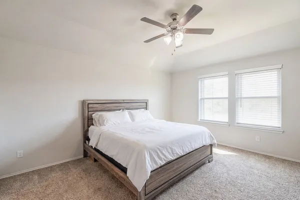 a bed sitting in a bedroom next to a window