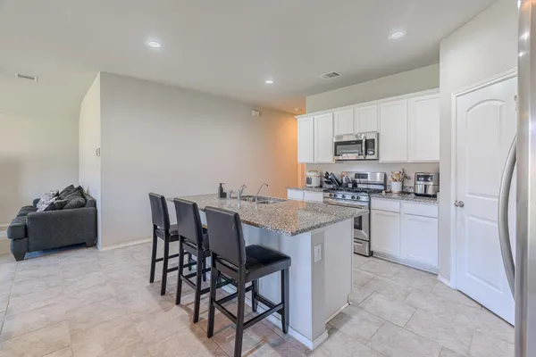 a kitchen with kitchen island white cabinets and refrigerator