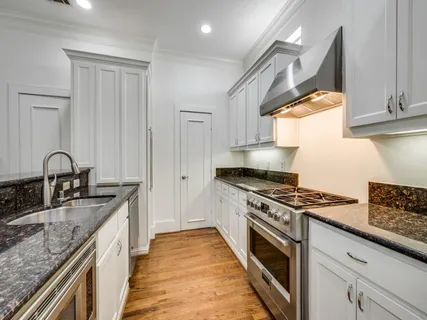 a kitchen with stainless steel appliances granite countertop a stove a sink and a microwave