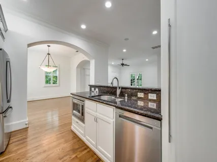 a kitchen with granite countertop a sink and cabinets
