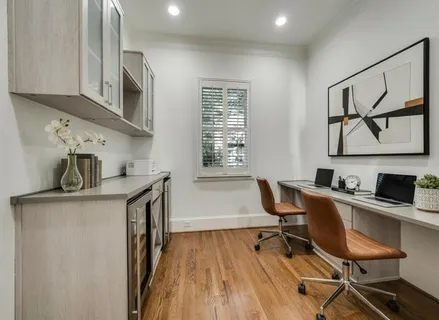 a view of a workspace with furniture and a window