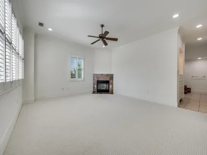 an empty room with windows and fireplace