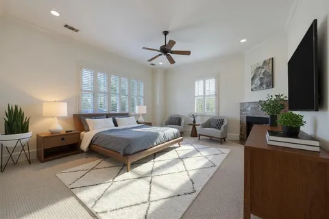 a spacious bedroom with a bed a couch and a flat screen tv