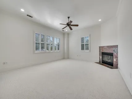 an empty room with windows and fireplace