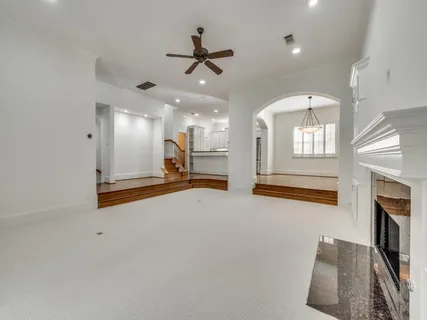 a view of an empty room with a fireplace and a window