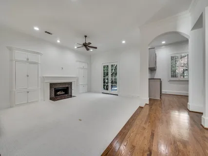 a view of empty room with wooden floor and a fireplace