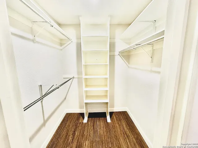 a view of walk in closet with empty racks