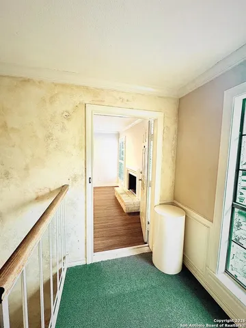 a view of an empty room and bathroom with wooden floor and windows