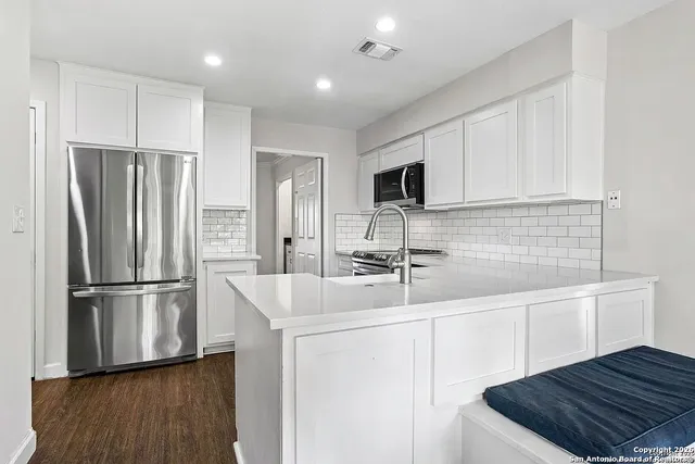 a kitchen with kitchen island a sink stainless steel appliances and cabinets