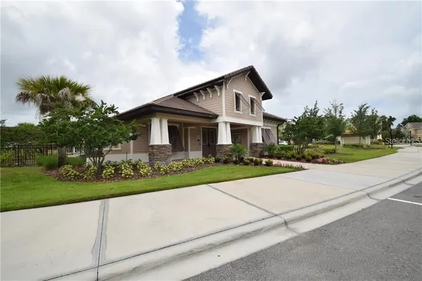a front view of a house with a yard and potted plants